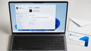 Laptop showing Windows 11 activation settings beside a printed Windows product key card