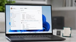 Windows 11 requirements: laptop with Settings About page, TPM chip and CPU on the desk